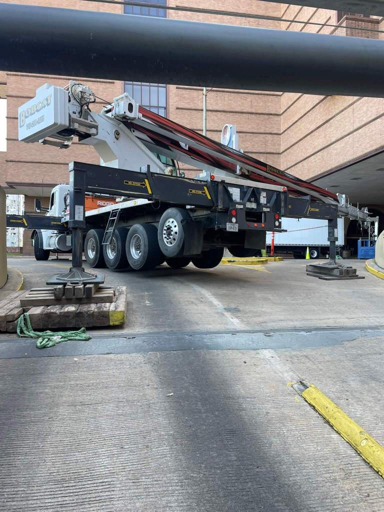 Mobile crane lifting rooftop HVAC unit on a commercial building in Houston by Sean Gets Cranes